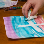 Photo of a child's hand using watercolors on a table